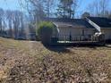 Expansive backyard with a large deck, a lush lawn, mature trees, and ample space for outdoor entertaining and recreation at 6536 Pineburr Rd, Charlotte, NC 28211