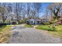 Street view of a charming home with mature landscaping, a detached carport, and a gravel driveway on a sunny day at 842 Mary Knoll Ct, Rock Hill, SC 29730