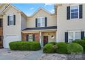 Inviting townhome featuring a well-manicured lawn, brick accents, and a convenient single-car garage at 9068 Cinnabay Dr, Charlotte, NC 28216