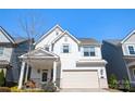 Charming two-story home with a well-manicured lawn, a front porch, and an attached two-car garage at 15115 Rocky Bluff Loop, Davidson, NC 28036