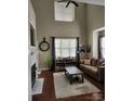 Spacious living room with vaulted ceilings, large windows, a fireplace, and hardwood floors at 18224 Taffrail Way, Cornelius, NC 28031