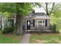 View of home with gray brick, dark shutters, and a small porch visible from the sidewalk at 1900 Union St, Charlotte, NC 28205