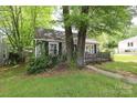 Exterior view shows a gray home and lawn shaded by mature trees at 1900 Union St, Charlotte, NC 28205