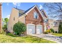 Beautiful brick home featuring a two-car garage, manicured lawn and partial view of a charming entrance at 2014 Arbor Crest Ct, Charlotte, NC 28262
