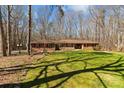 Beautiful brick ranch-style home with red shutters surrounded by a green lawn and mature trees at 220 Gregory Rd, Salisbury, NC 28147