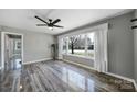 Bright living room featuring hardwood floors, neutral paint, a ceiling fan, and large bay windows at 2301 Shamrock Dr, Charlotte, NC 28205