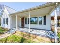 Inviting front porch with white columns, providing a comfortable and stylish outdoor space at 260 Penninger Dr, Woodleaf, NC 27054