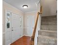 Welcoming foyer featuring hardwood floors, staircase, and a conveniently located coat closet at 3217 Deep Meadow Ln, Charlotte, NC 28210
