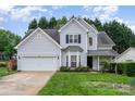Beautiful two-story home with grey siding, lush green lawn, and an attached two-car garage at 3905 Farlow Rd, Charlotte, NC 28269