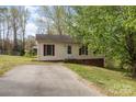 Ranch home featuring light siding, dark shutters and trim, with a driveway leading up to the front entrance at 410 E Lee Ave, Bessemer City, NC 28016
