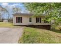 Charming single-story home featuring red shutters, siding and a gravel driveway surrounded by a lush, green lawn at 410 E Lee Ave, Bessemer City, NC 28016