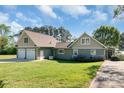 Charming home exterior with a spacious two-car garage and lush green lawn, creating a welcoming curb appeal at 421 Tranquil Bay Cir, Norwood, NC 28128