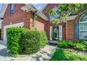 Brick home featuring a welcoming front entrance with a garden and well-manicured lawn and lush landscaping at 4302 Ethel Sustar Dr, Monroe, NC 28110
