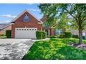 Beautiful brick home showcasing a well-maintained front yard with mature trees and an attached two-car garage at 4302 Ethel Sustar Dr, Monroe, NC 28110