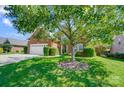 Charming home featuring lush front lawn, mature shade trees, and a brick facade, all under a bright blue sky at 4302 Ethel Sustar Dr, Monroe, NC 28110
