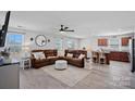 Open concept living room seamlessly connects to the kitchen, featuring hardwood floors and a ceiling fan at 4318 Greenleaf Nw St, Concord, NC 28027