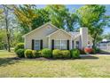 Charming single-story home featuring a well-manicured lawn and tasteful landscaping with black shutters at 602 S Church St, Lowell, NC 28098