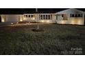 Charming home exterior at night, featuring manicured lawn and decorative lighting at 614 Hazelwood Dr, Albemarle, NC 28001
