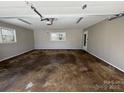 Spacious two car garage with overhead lighting and natural light from a window at 614 Hazelwood Dr, Albemarle, NC 28001