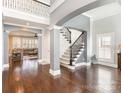 Open foyer with dark wood floors, neutral walls, and a staircase with wrought iron spindles at 717 Barossa Valley Nw Dr, Concord, NC 28027