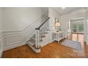 Bright foyer with hardwood floors, staircase, and decorative wainscoting at 7700 Red Oak Ln, Charlotte, NC 28226