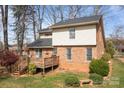 Backyard view showcasing a deck, mature trees, and landscaping on a verdant lawn at 8260 Graham Rd, Denver, NC 28037