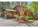 Beautiful log home with an attached garage, lovely landscaping, and a red front door at 1007 Mistywood Ln, Concord, NC 28027