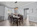 Bright dining room with modern light fixture, wooden table set, large windows, and neutral wall paint at 1016 Council Fire Cir, Indian Trail, NC 28079