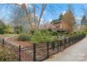 Well-manicured backyard with mature trees and elegant black metal fencing surrounding the property at 106 Brookwood Ln, Taylorsville, NC 28681