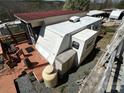 Aerial view shows a camper with deck and shed under a clear blue sky at 108 Robin Ln, New London, NC 28127
