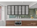 Contemporary kitchen featuring glass-front cabinets, modern appliances, and tiled backsplash at 1300 Queens Rd # 408, Charlotte, NC 28207