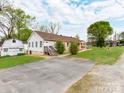 Back of the home, featuring a small outbuilding and a paved driveway and parking area at 1401 Birch St, Kannapolis, NC 28081