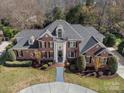 An aerial view showing the home's brick exterior, manicured lawn and mature trees surrounding the property at 1511 Churchill Downs Dr, Waxhaw, NC 28173