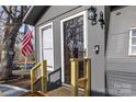 Close up of main entrance door with gray siding, storm door, and wooden porch steps at 167 Holly Harbor Trl # 169/170, Mount Gilead, NC 27306