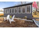 Attractive sunroom exterior with Adirondack chairs and well-maintained landscaping at 167 Holly Harbor Trl # 169/170, Mount Gilead, NC 27306