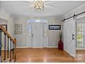 Charming foyer featuring hardwood floors, barn door, and modern decor elements, creating a stylish ambiance at 2016 Monaghan Ct, Matthews, NC 28105