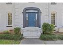 Close-up view of the front door with its elegant archway, sidelights, and complementary landscaping at 2016 Monaghan Ct, Matthews, NC 28105