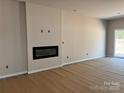 Modern living room with sleek fireplace and sliding glass door access to backyard at 2019 Mcdonald Dr, Charlotte, NC 28216