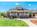 Inviting brick home featuring a classic front porch, complemented by a well-maintained yard at 2236 Tuckaway Rd, Rock Hill, SC 29730