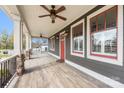 Expansive front porch featuring ceiling fans, red-trimmed windows, and wood-look flooring at 232 Cromer St, Charlotte, NC 28208