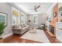 Cozy living room with hardwood floors, a brick fireplace, and plenty of natural light at 232 Cromer St, Charlotte, NC 28208