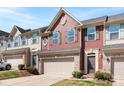Charming townhome featuring a red facade, brick accents, and a two-car garage at 2446 Alyssa Ln, Charlotte, NC 28208