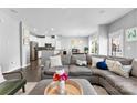 Bright, open-concept living area with a gray sectional sofa and wood flooring at 2446 Alyssa Ln, Charlotte, NC 28208