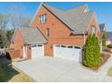 Angle view of brick home with a three car garage and long driveway at 2616 Creek Manor Dr, Waxhaw, NC 28173