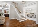 Open foyer featuring hardwood floors, staircase, and an entry to the living room at 3100 Stanway Ct, Waxhaw, NC 28173