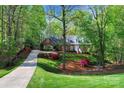 Scenic view of brick home nestled among lush greenery, highlighting landscaping and driveway at 3412 Country Club Dr, Gastonia, NC 28056