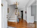 Elegant foyer with hardwood floors, staircase, chandelier and neutral wall paint color at 3412 Country Club Dr, Gastonia, NC 28056