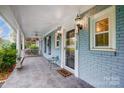 Cozy front porch with tiled floor, white pillars and railings, and a ceiling fan for outdoor comfort at 3726 Providence Rd, Charlotte, NC 28211