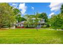 A beautiful lawn surrounds this charming home with an inviting front porch and lush, mature trees at 3726 Providence Rd, Charlotte, NC 28211