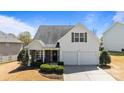 Traditional two-story home with a two-car garage, inviting front porch, and well-maintained landscaping on a sunny day at 3908 Parkers Ferry Rd, Fort Mill, SC 29715